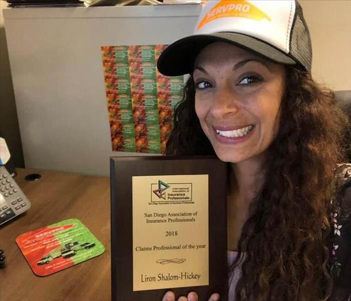 Employee with her Claims Professional of the Year award on a plaque.