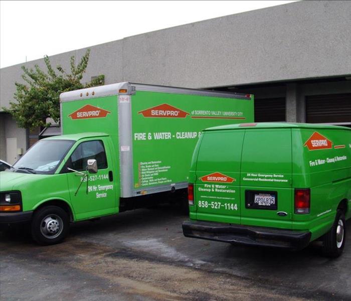 green box truck and green van with orange servpro logo